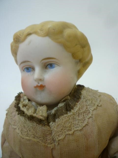 A parian china shoulder head doll with painted face Image