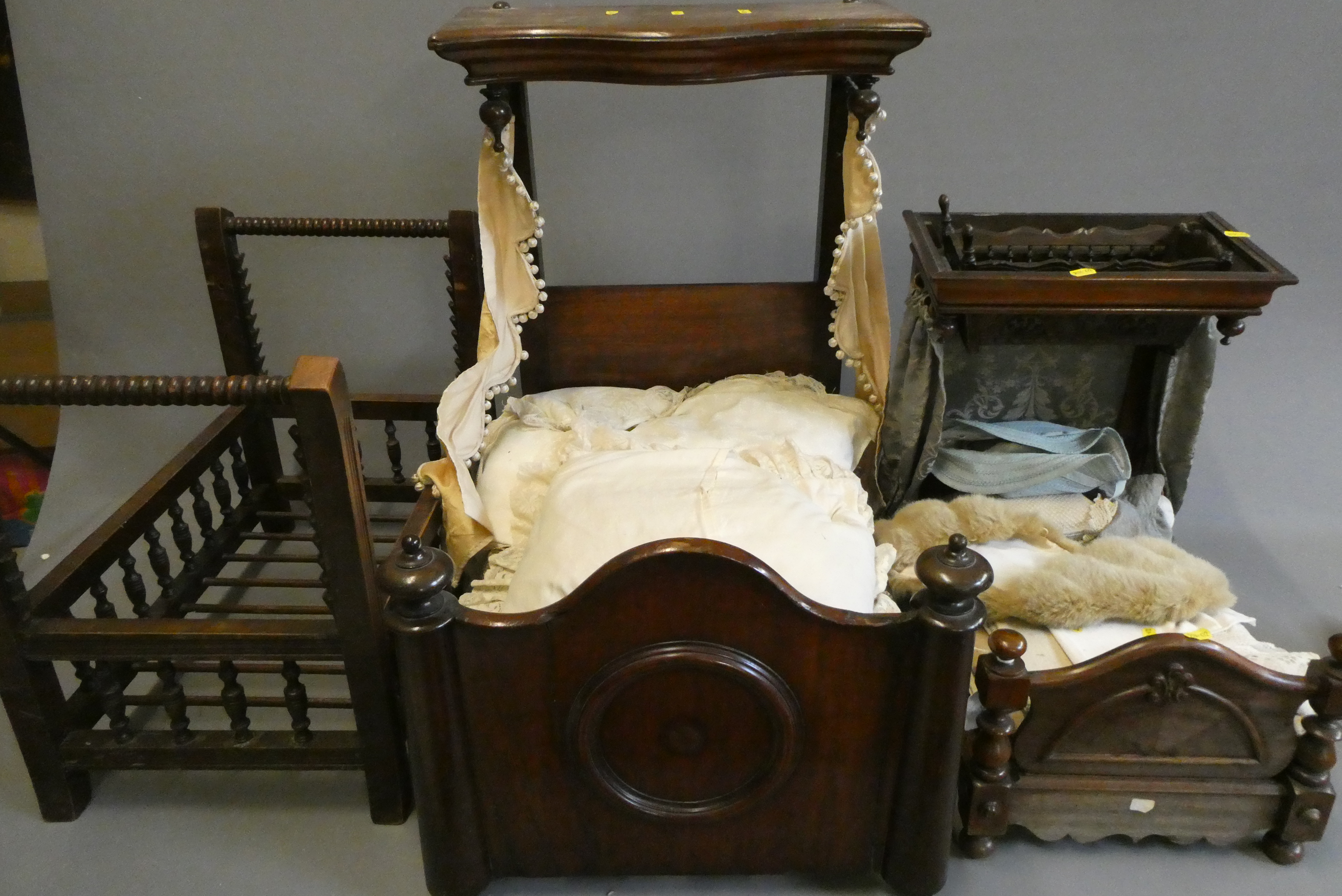 Three antique doll's beds, all of wood construction, comprising two half testers and one with turned Image