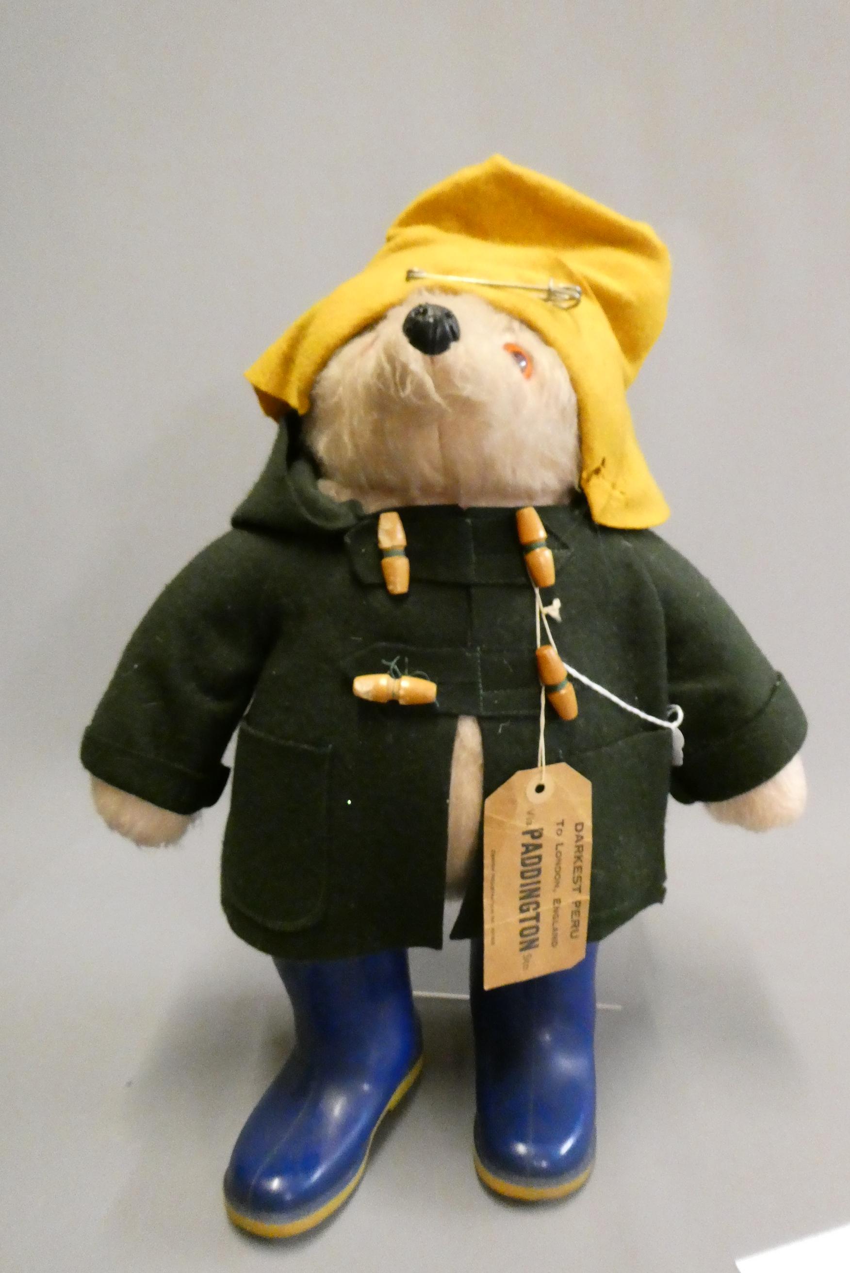 Vintage Paddington bear, with orange felt hat, green felt coat, blue Dunlop boots and cardboard Image