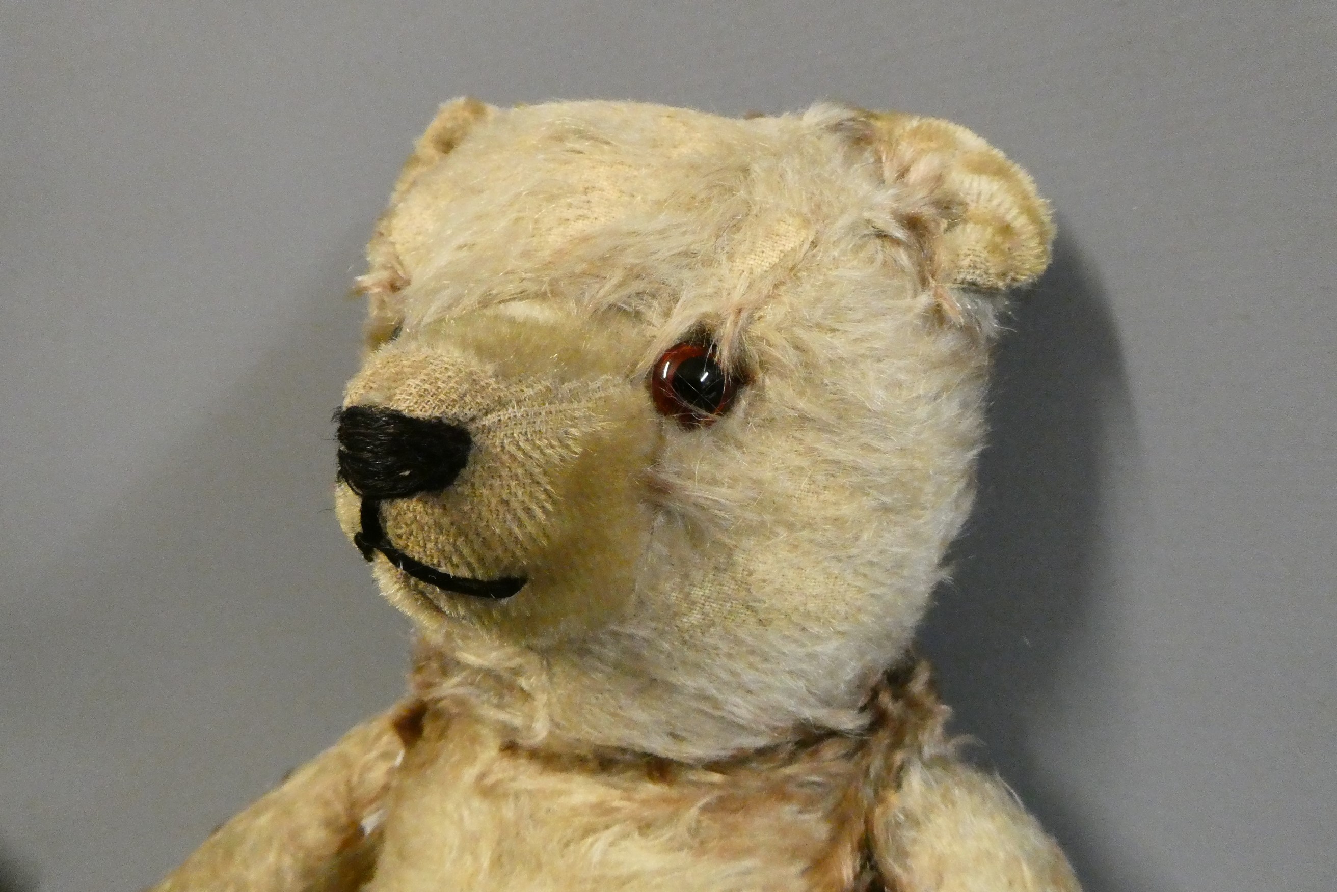 Vintage English centre seam teddy bear, with amber glass eyes, shaved muzzle, sewn nose, and later Image