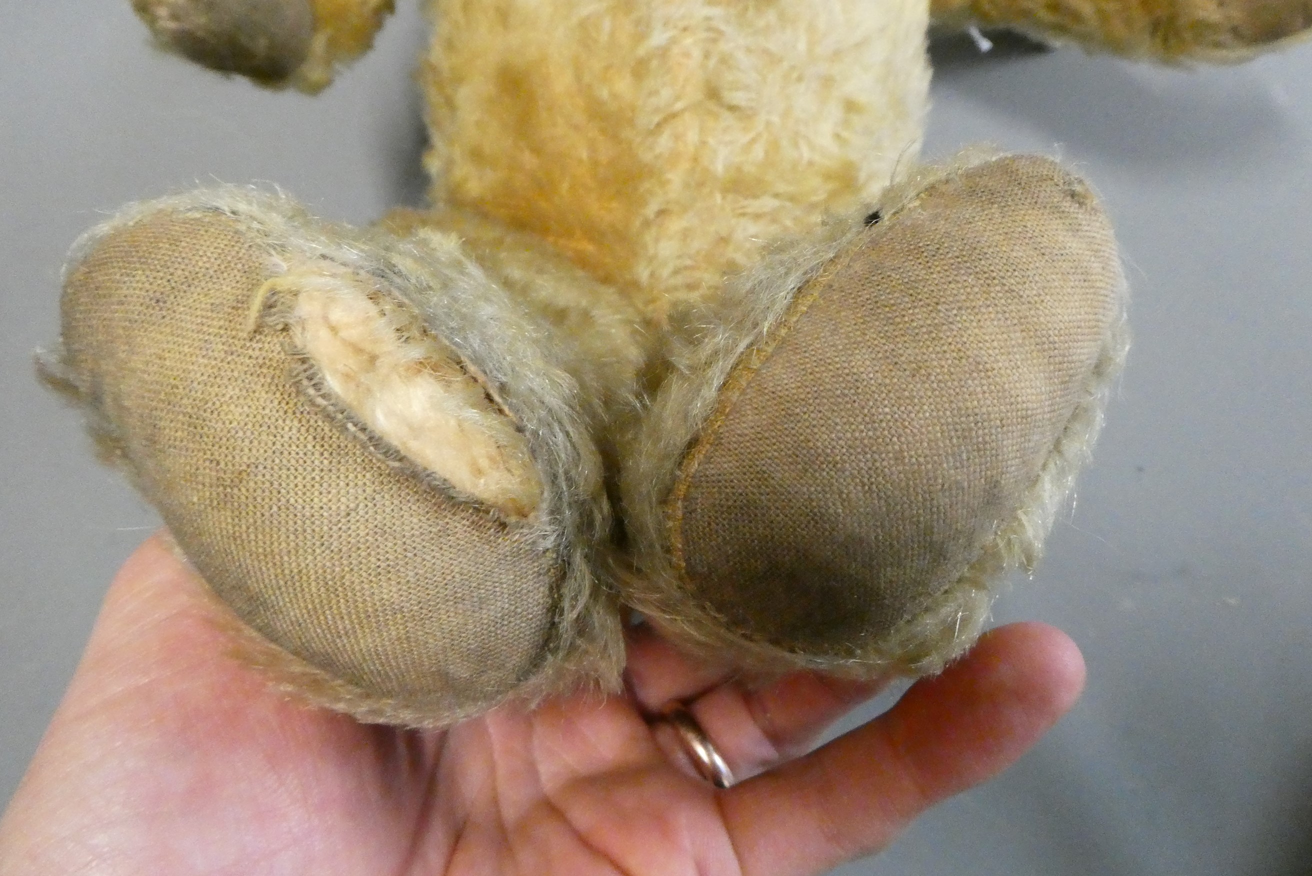 An English teddy bear, possibly Chiltern, with clear glass eyes, sewn nose, jointed body and fabric Image