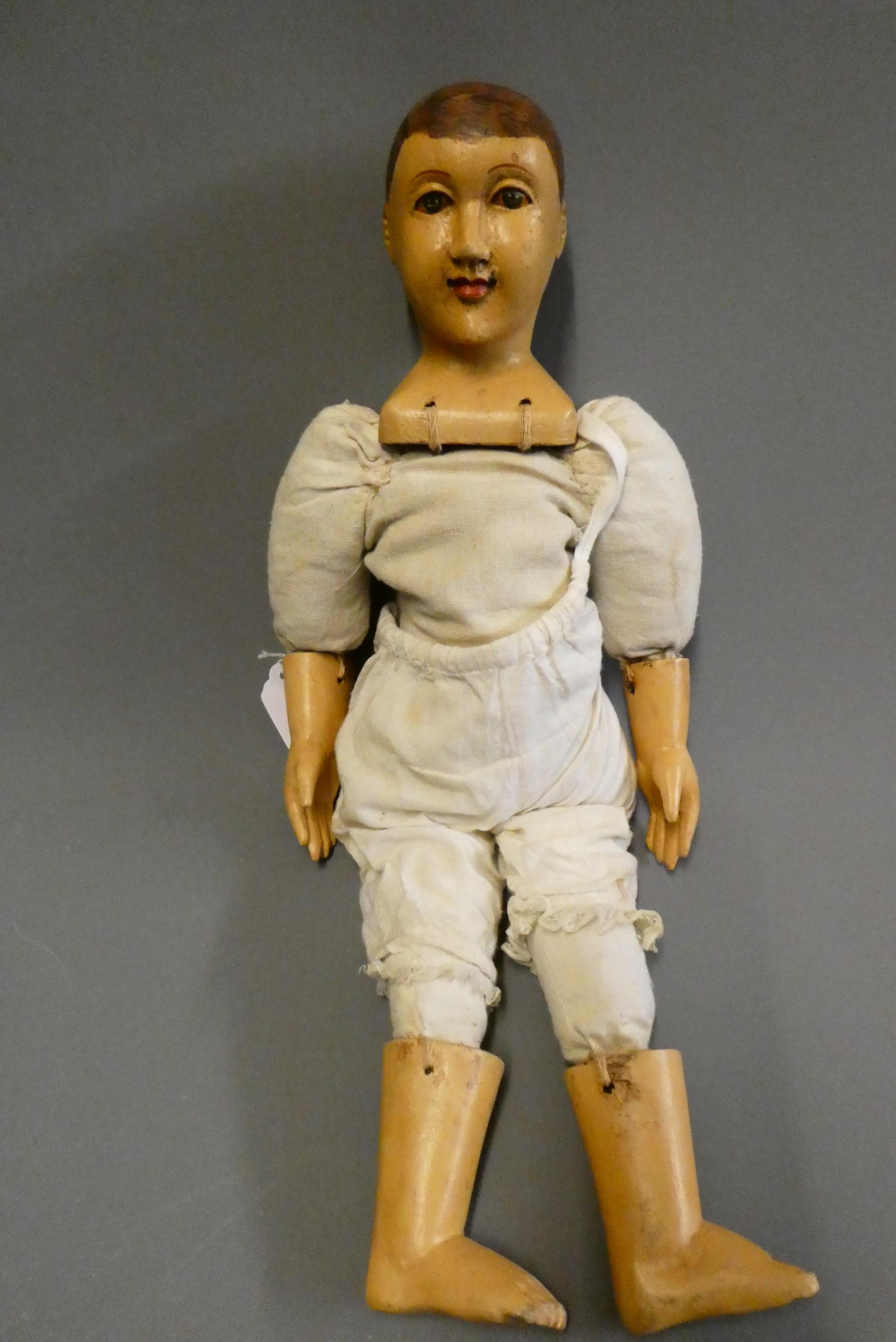 A folk art male doll, possibly a Santos doll, with carved wood and plaster head, painted features, Image