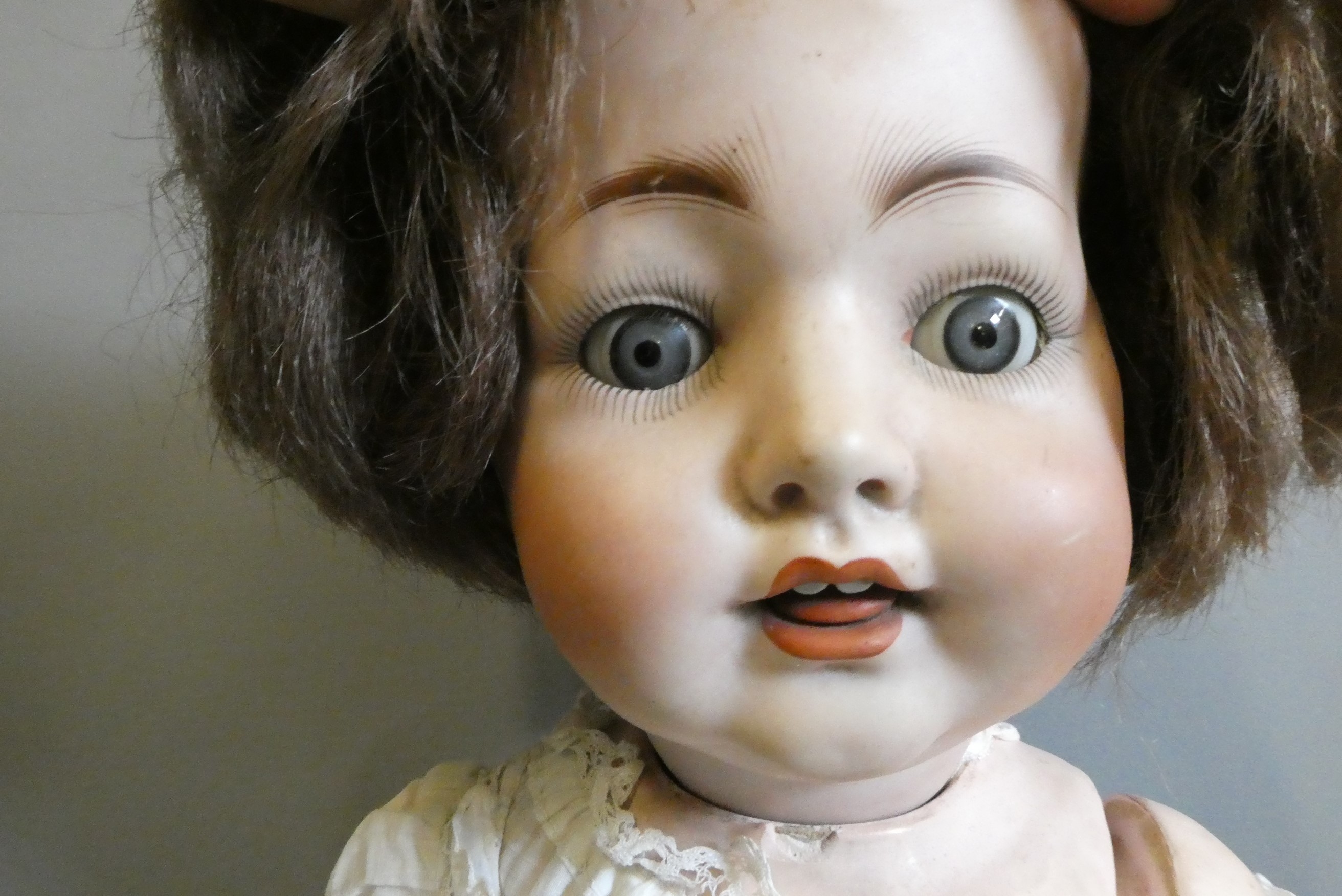 A bisque socket head character doll, with blue glass fixed eyes, open mouth, teeth, tongue, brown Image