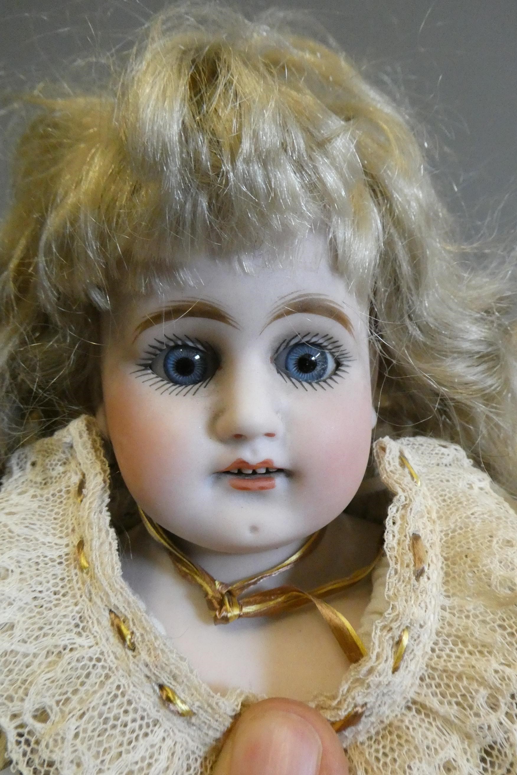 A bisque shoulder head doll, with blue glass sleeping eyes, open mouth, teeth, kid body with jointed Image