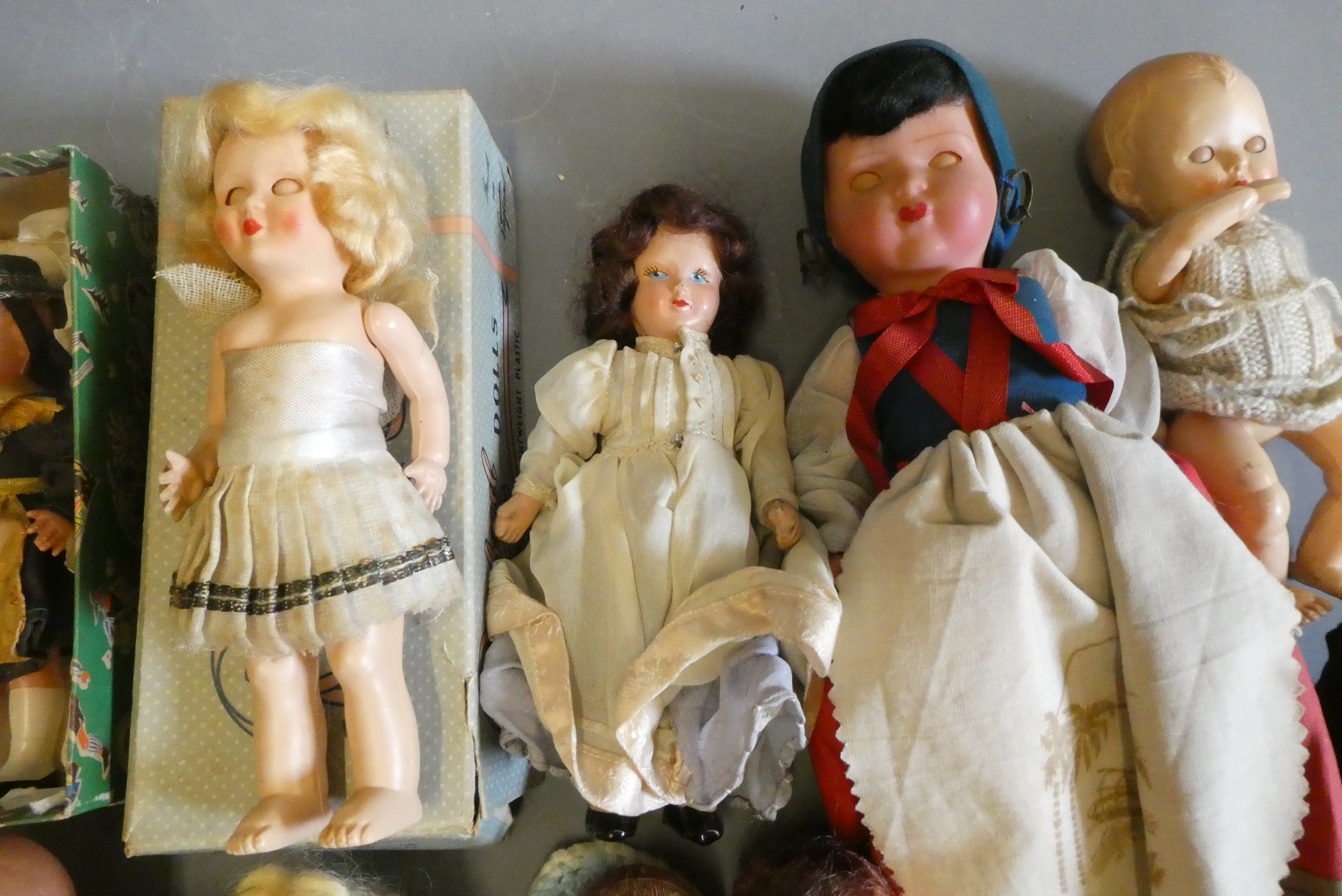 A box of vintage celluloid dolls including a Rosebud doll and others, three in original boxes Image