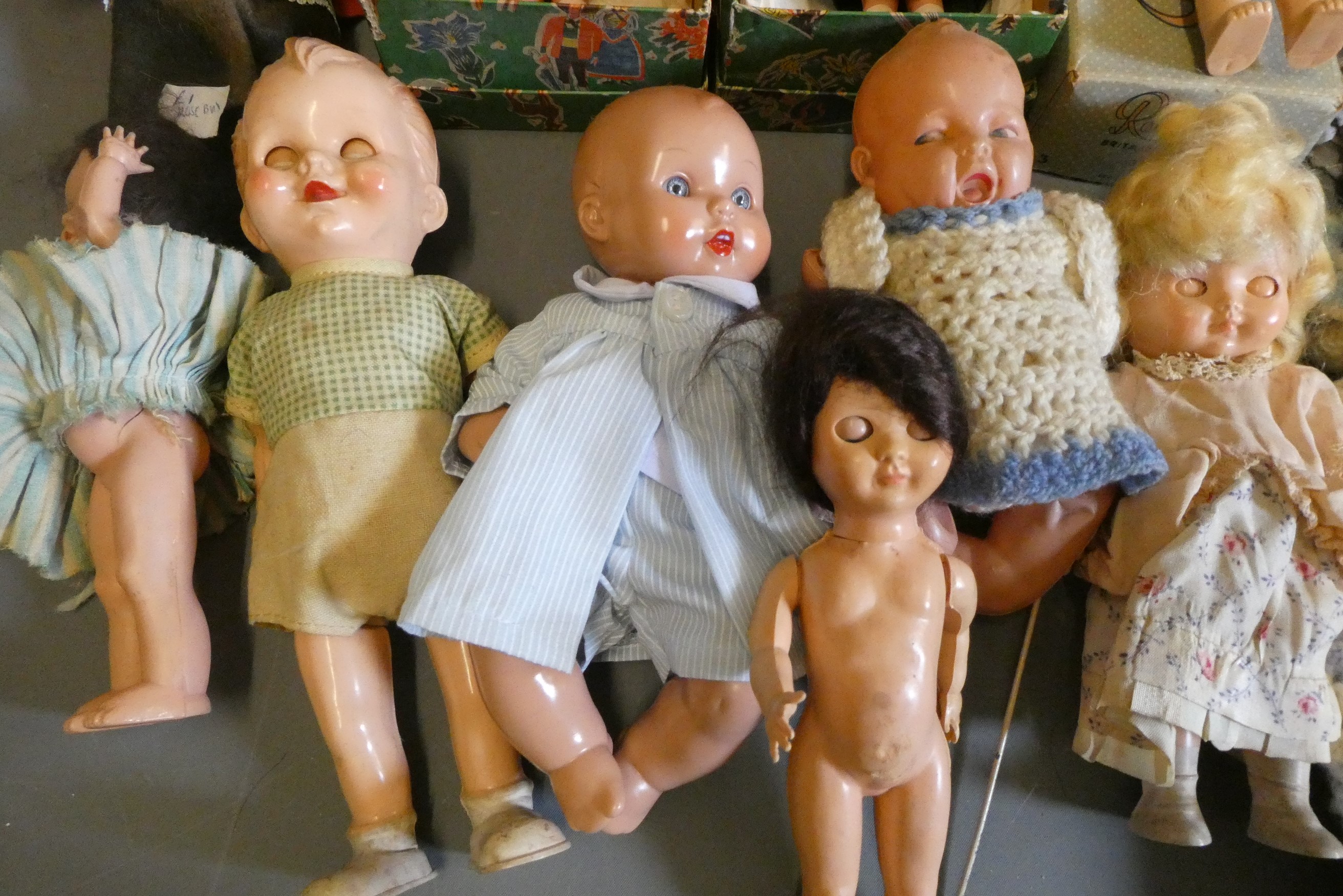 A box of vintage celluloid dolls including a Rosebud doll and others, three in original boxes Image