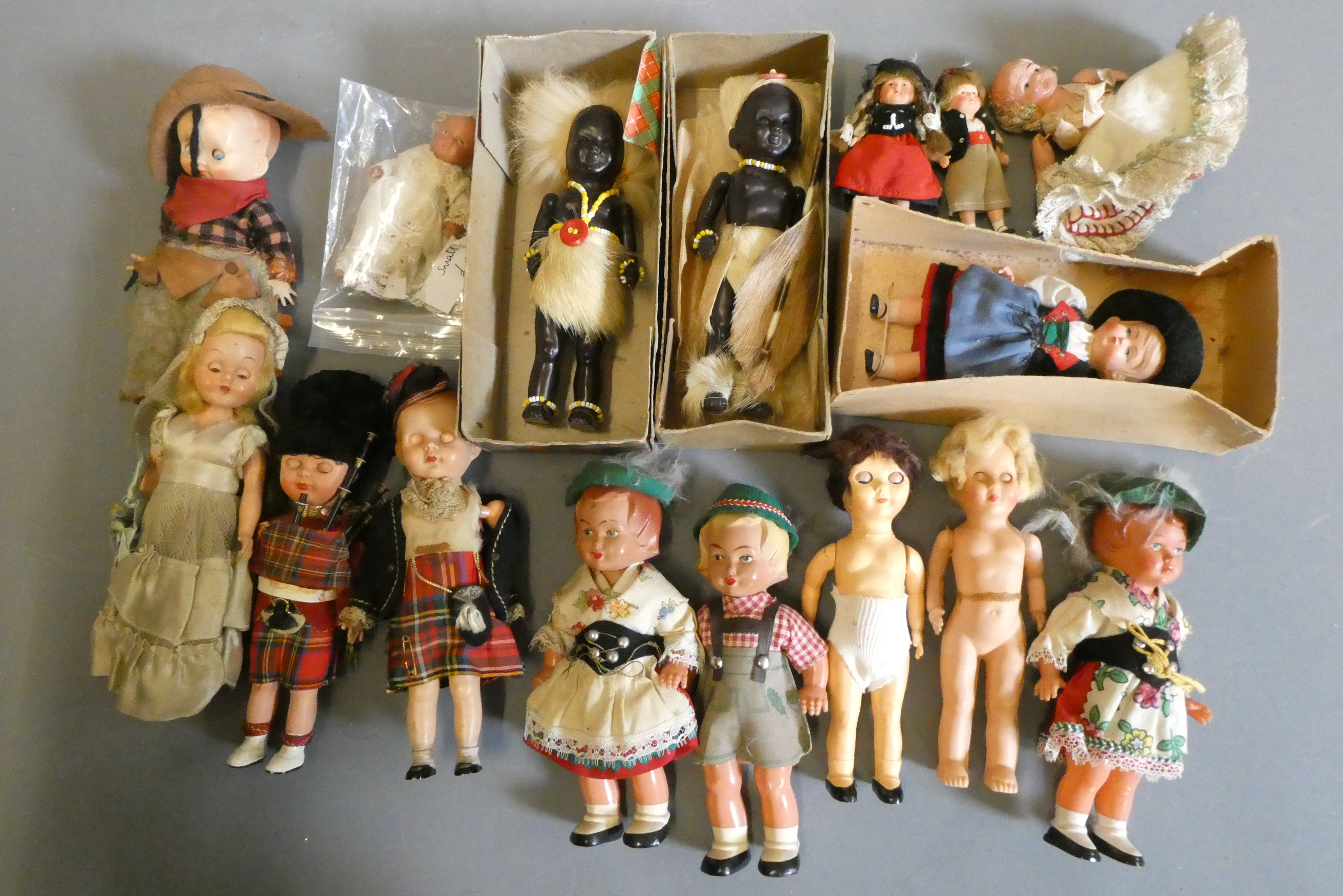 Two boxes of small vintage celluloid dolls, including Scotch dolls and two Zulus Image