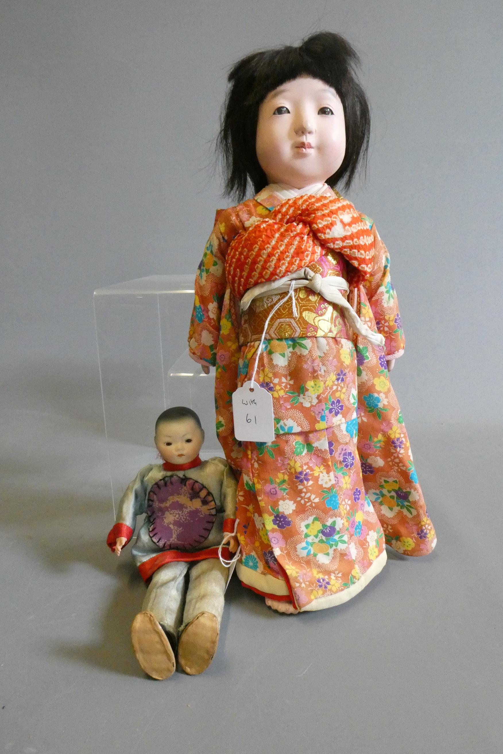 Two oriental dolls comprising an 11" bisque flange neck boy with sleeping eyes Image