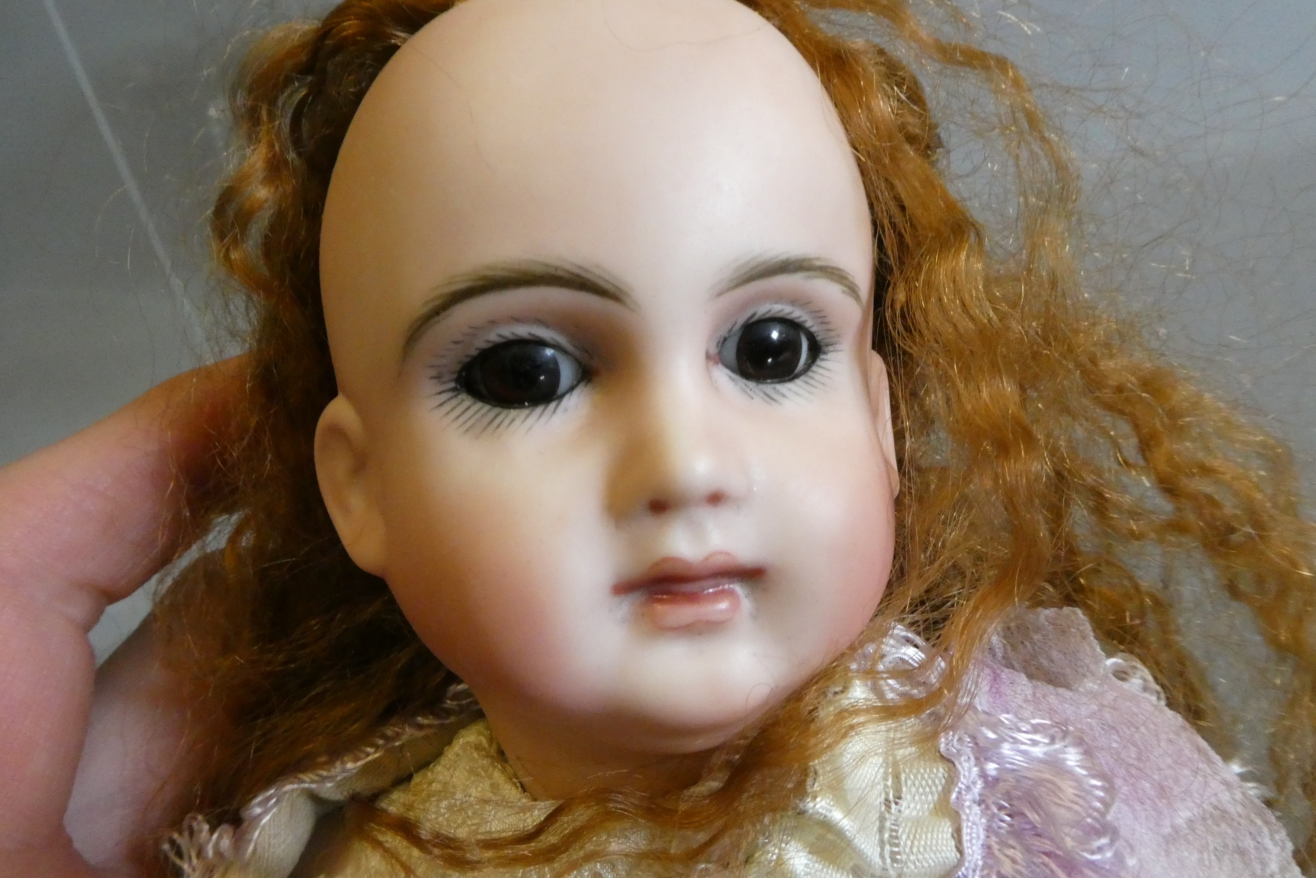 Three reproduction dolls, comprising a Jumeau MY91 type doll, 23" long, a Simon & Halbig 1248 with Image