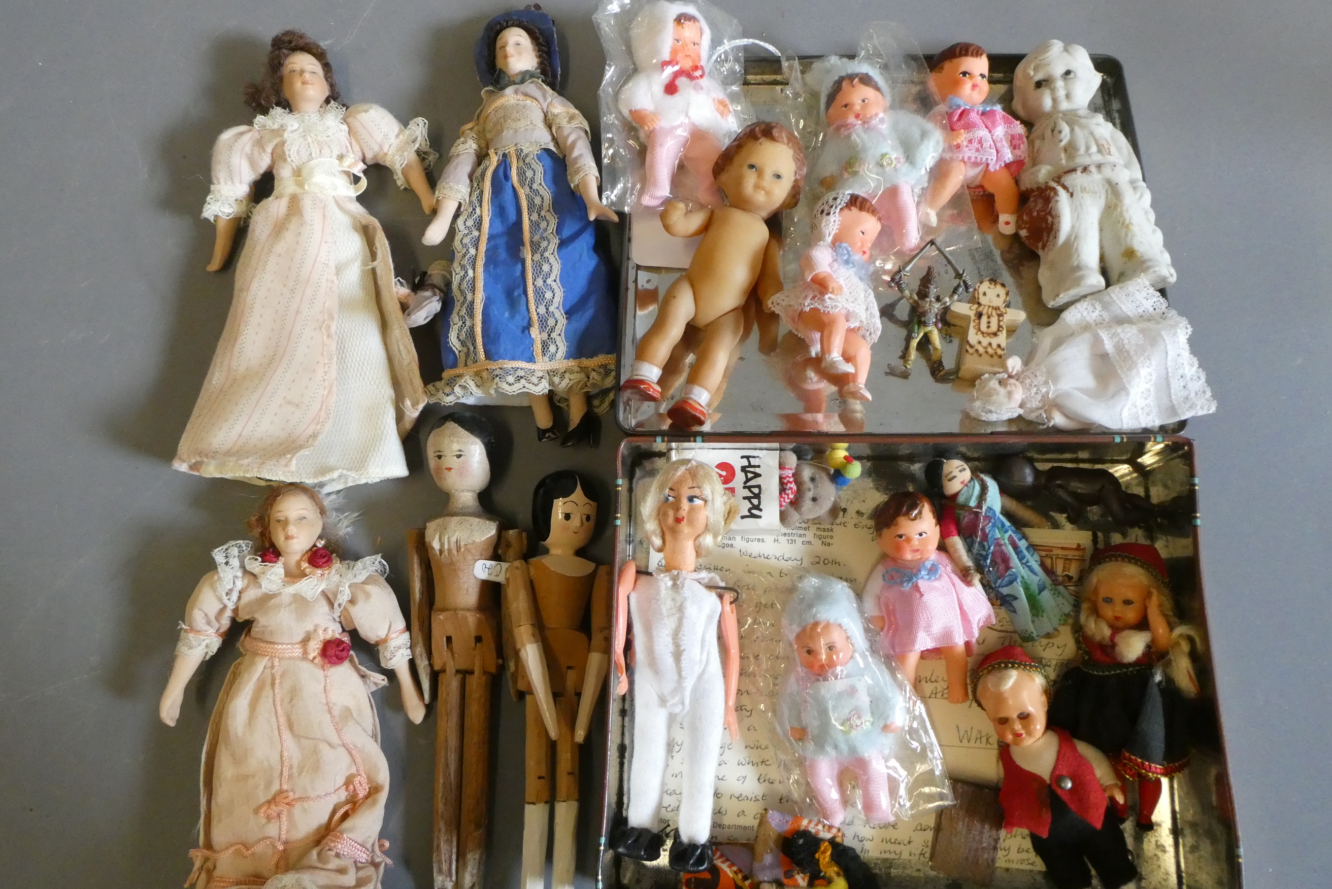 A collection of vintage and antique small dolls, including a Victorian peg doll, three bisque doll's Image