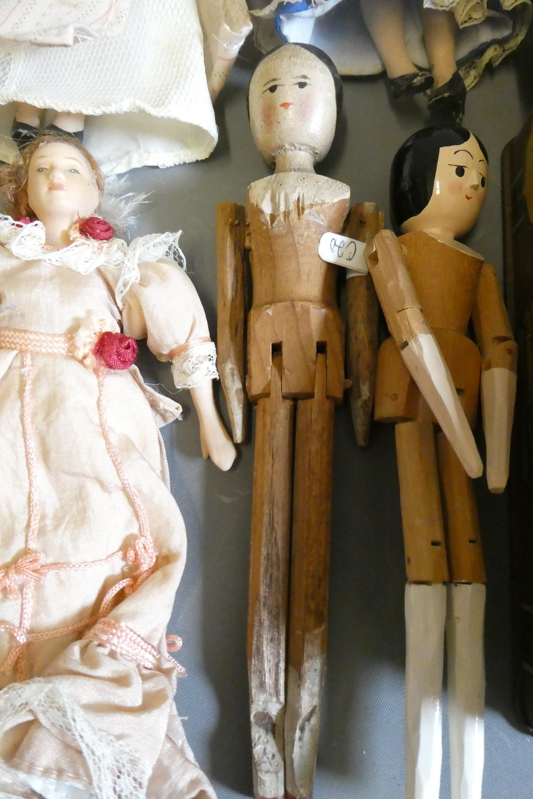 A collection of vintage and antique small dolls, including a Victorian peg doll, three bisque doll's Image