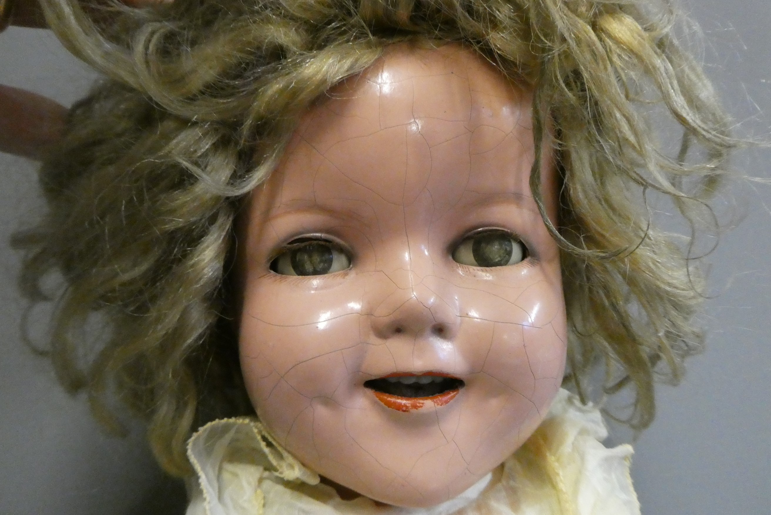 A Shirley Temple doll, with blue sleeping eyes, open mouth, teeth, blond wig, jointed composition Image