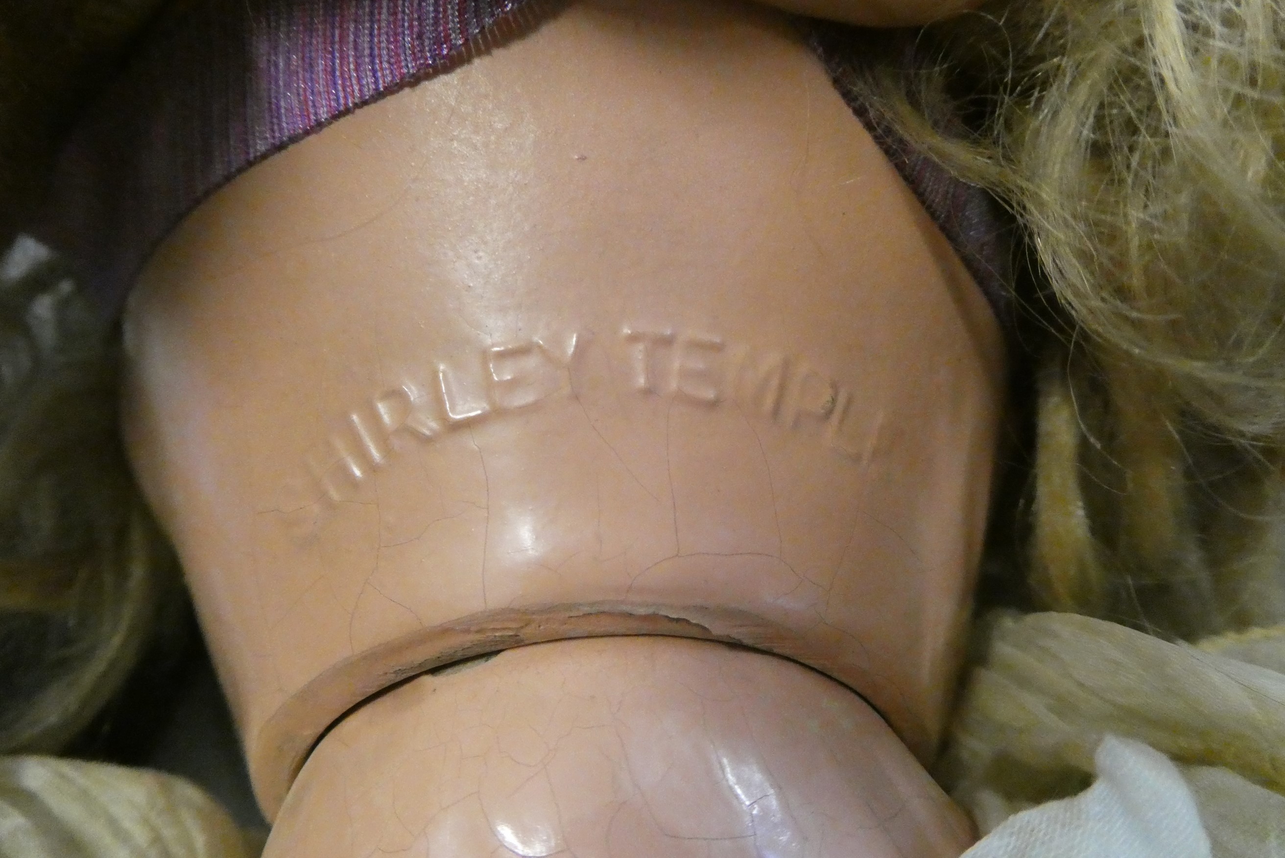 A Shirley Temple doll, with blue sleeping eyes, open mouth, teeth, blond wig, jointed composition Image
