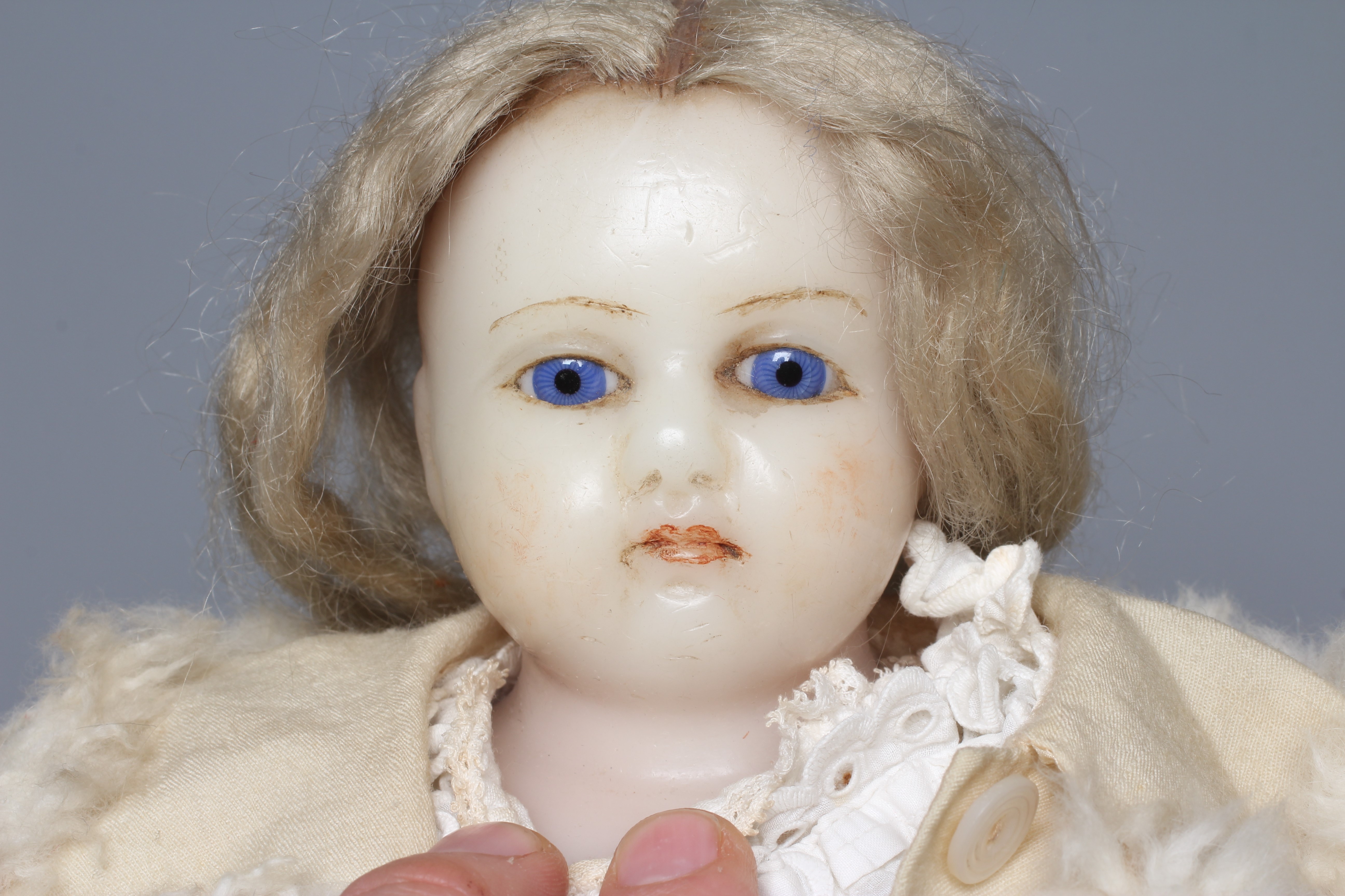 A Victorian poured wax shoulder head doll, with blue glass fixed eyes, closed mouth, blond wig, Image