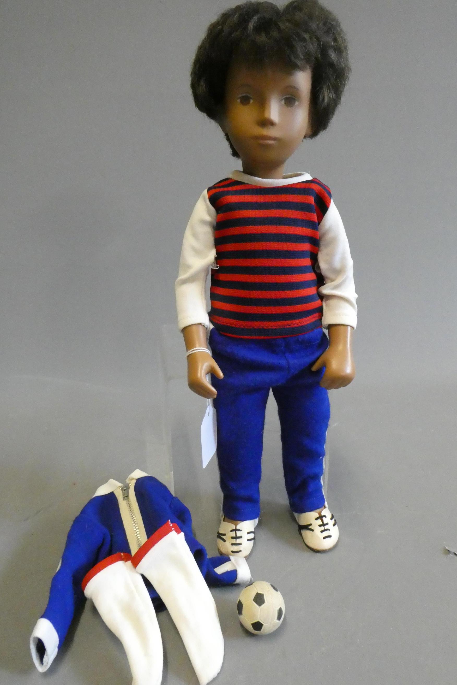 A Sasha boy doll, with brown hair, jointed body and striped top, 16" tall, with spare top, football Image