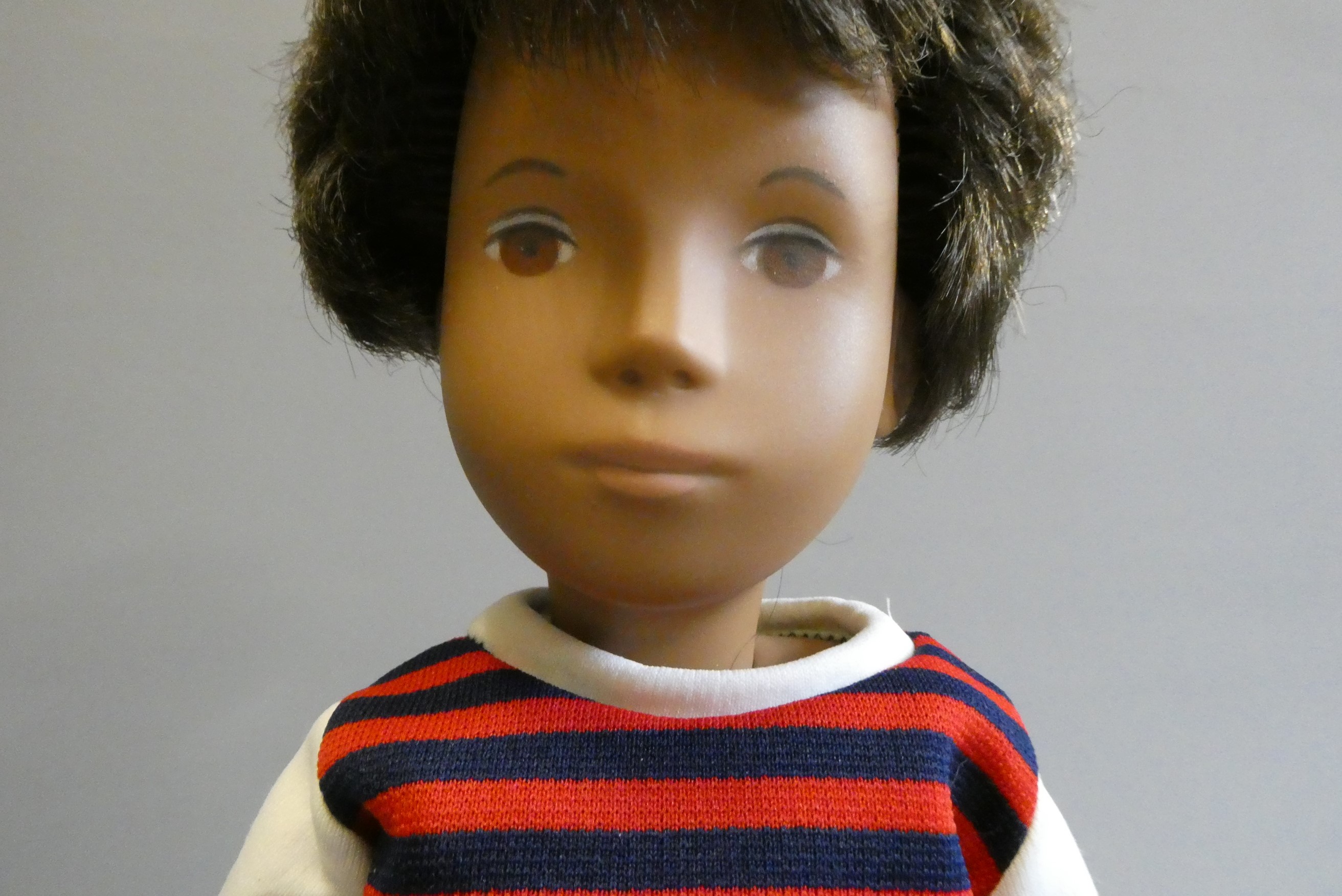 A Sasha boy doll, with brown hair, jointed body and striped top, 16" tall, with spare top, football Image