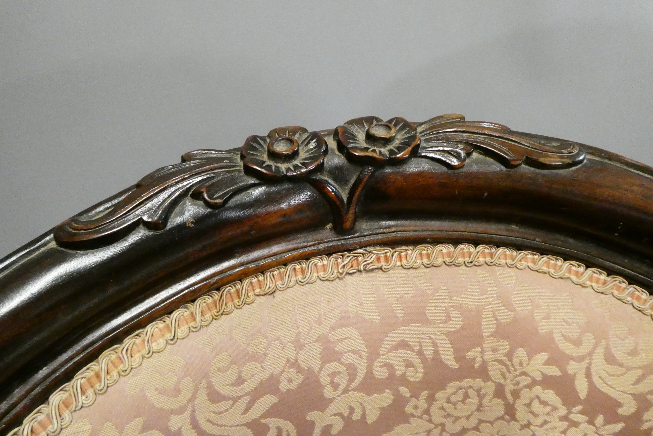 A pair of French style doll's chairs with carved wood frames, scroll arms and pink floral Image