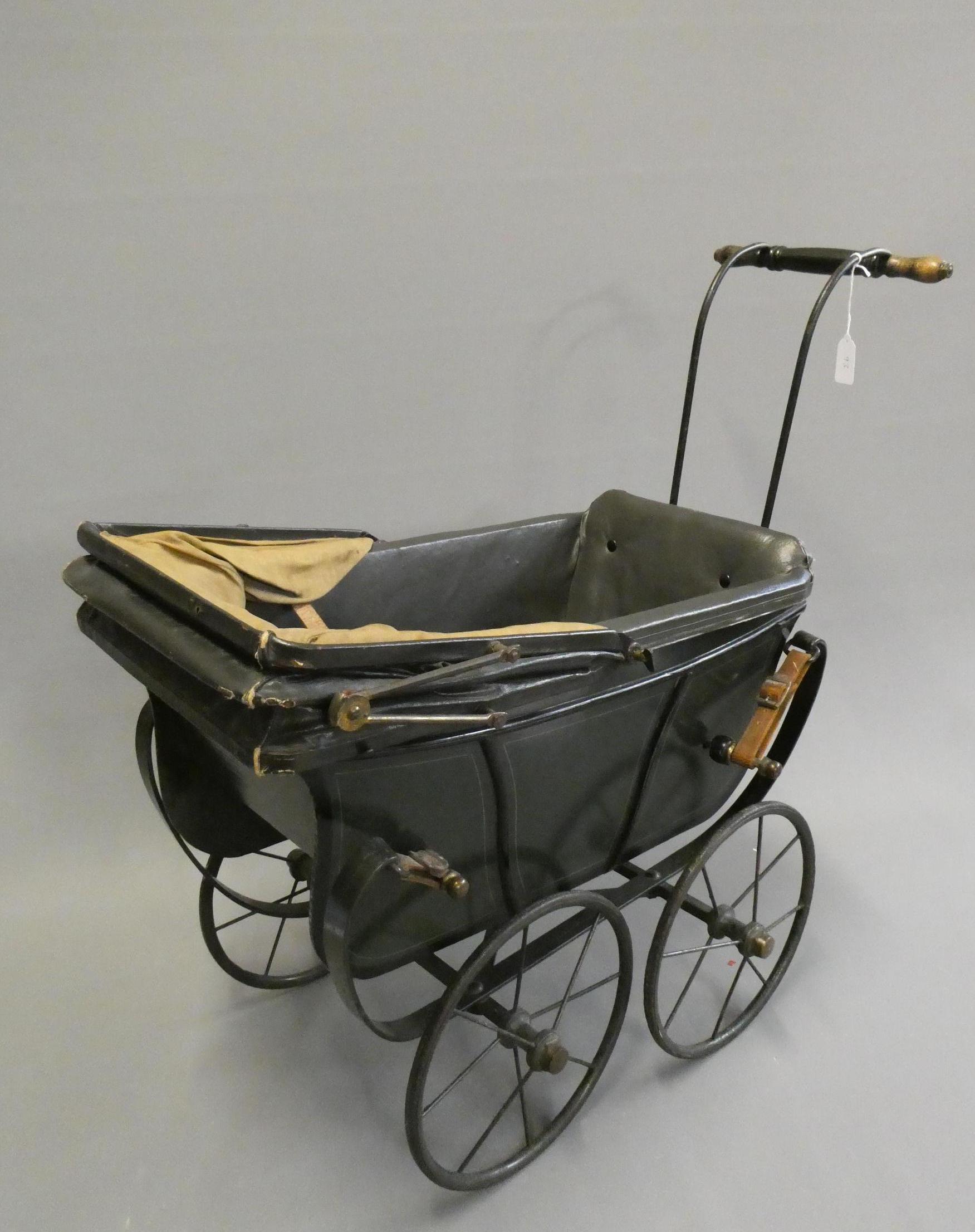 A late Victorian dolls twin pram, with leatherette hood, sprung base suspended on leather straps and Image