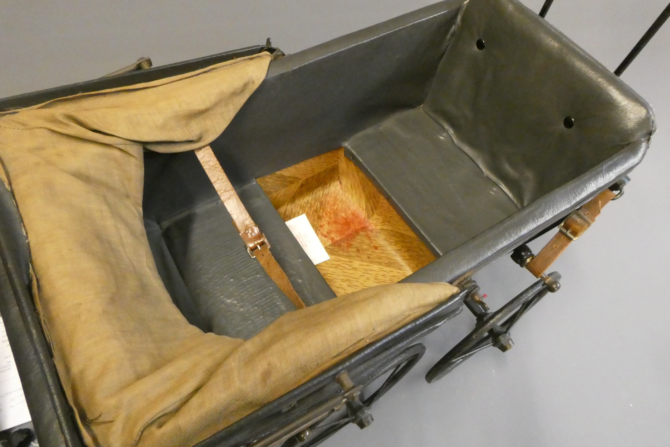 A late Victorian dolls twin pram, with leatherette hood, sprung base suspended on leather straps and Image
