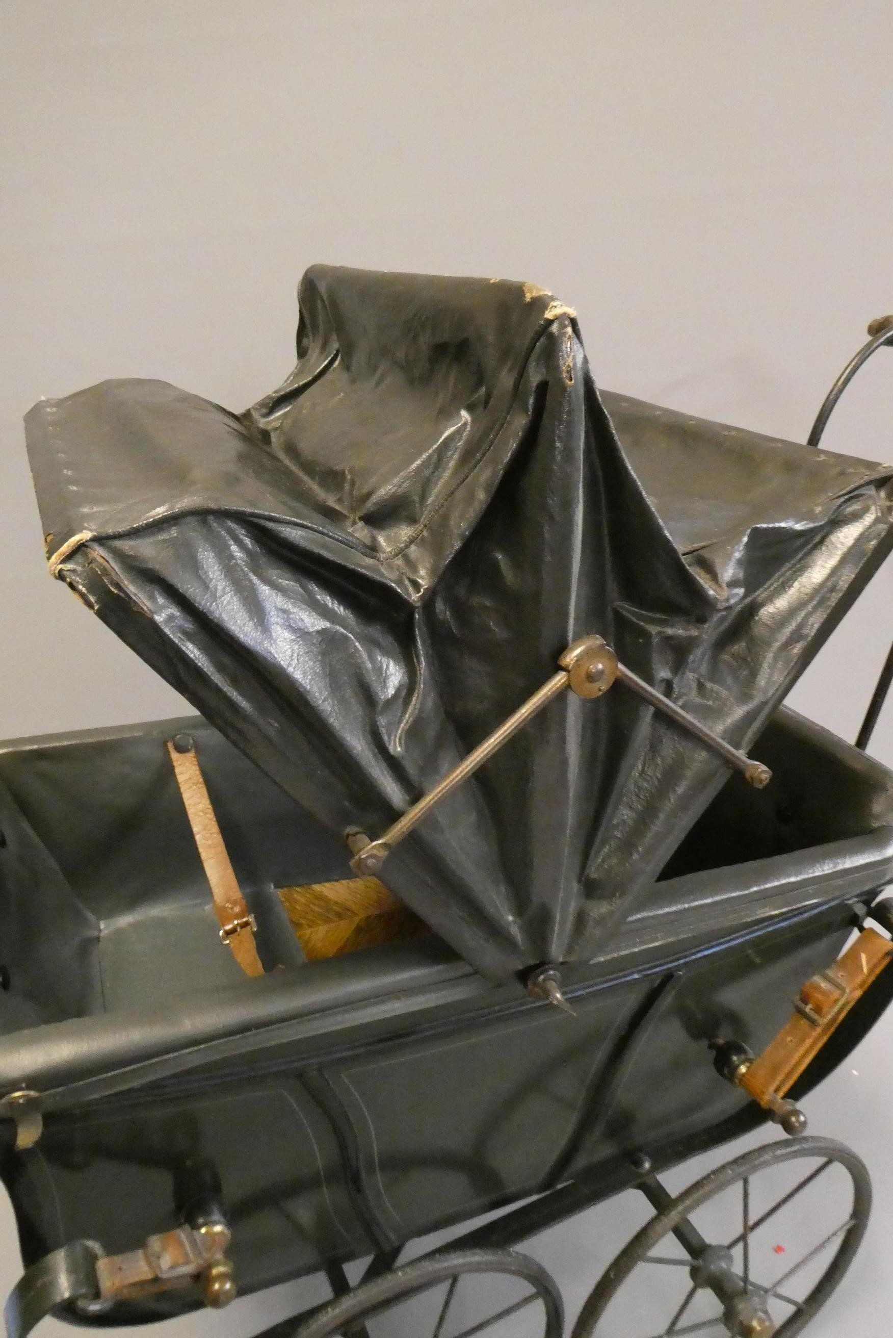 A late Victorian dolls twin pram, with leatherette hood, sprung base suspended on leather straps and Image