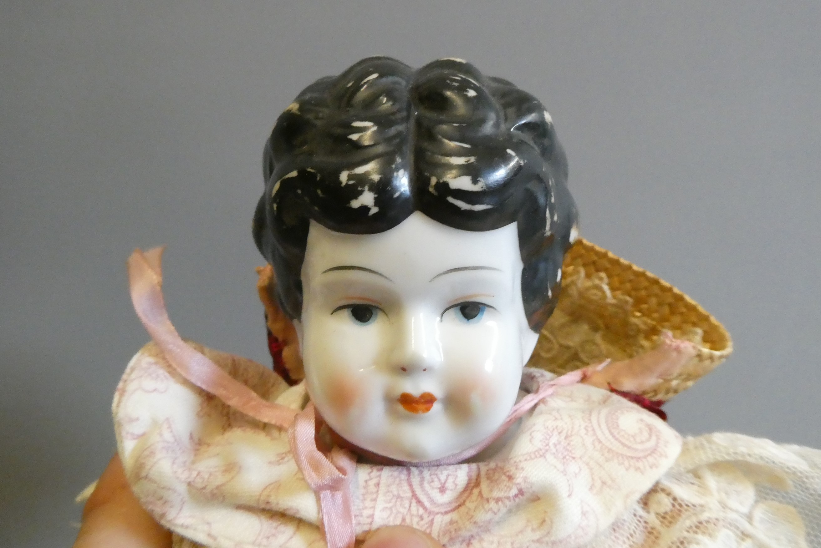 A Victorian china shoulder head doll, with moulded hair, painted features, fabric body, china lower Image