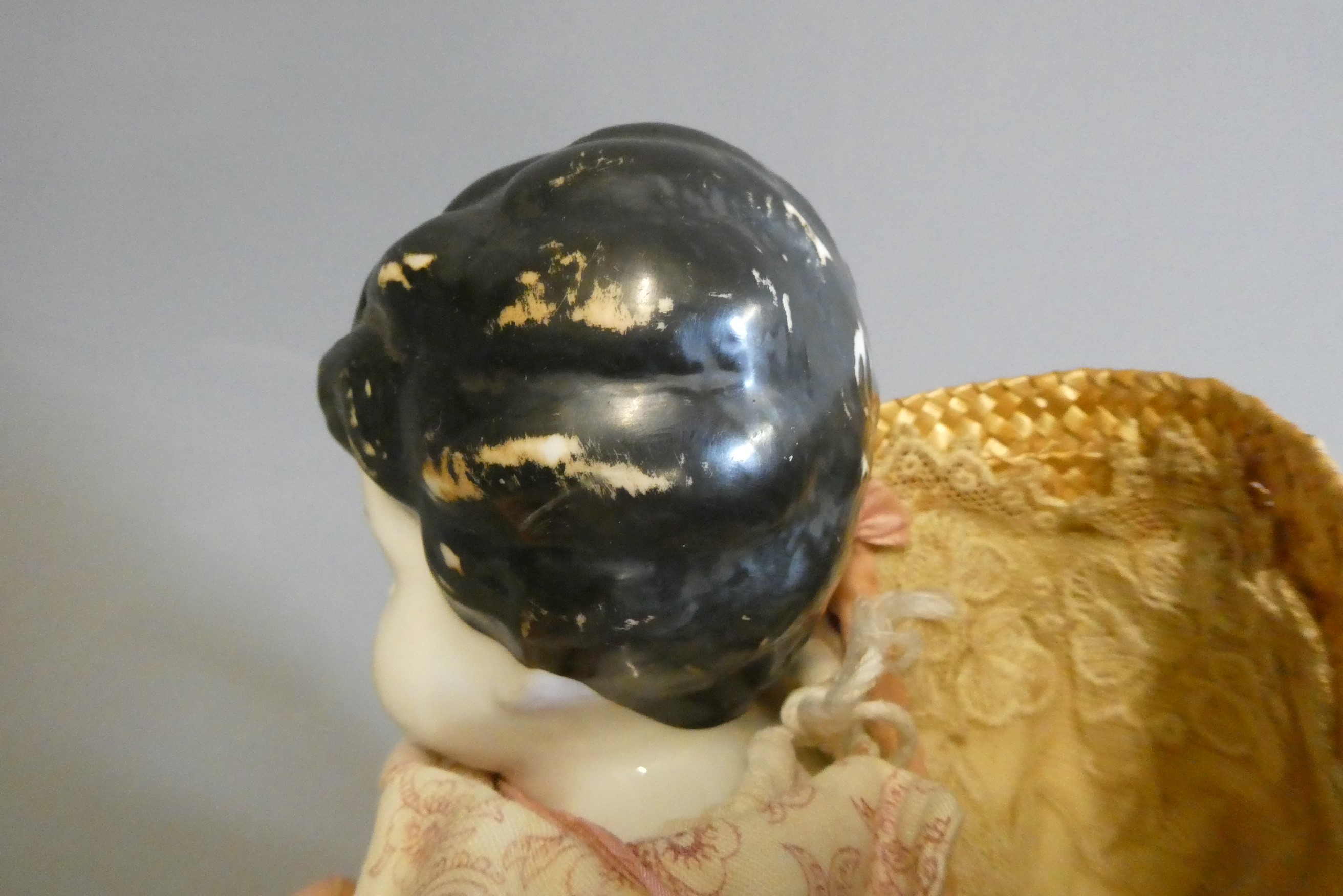 A Victorian china shoulder head doll, with moulded hair, painted features, fabric body, china lower Image