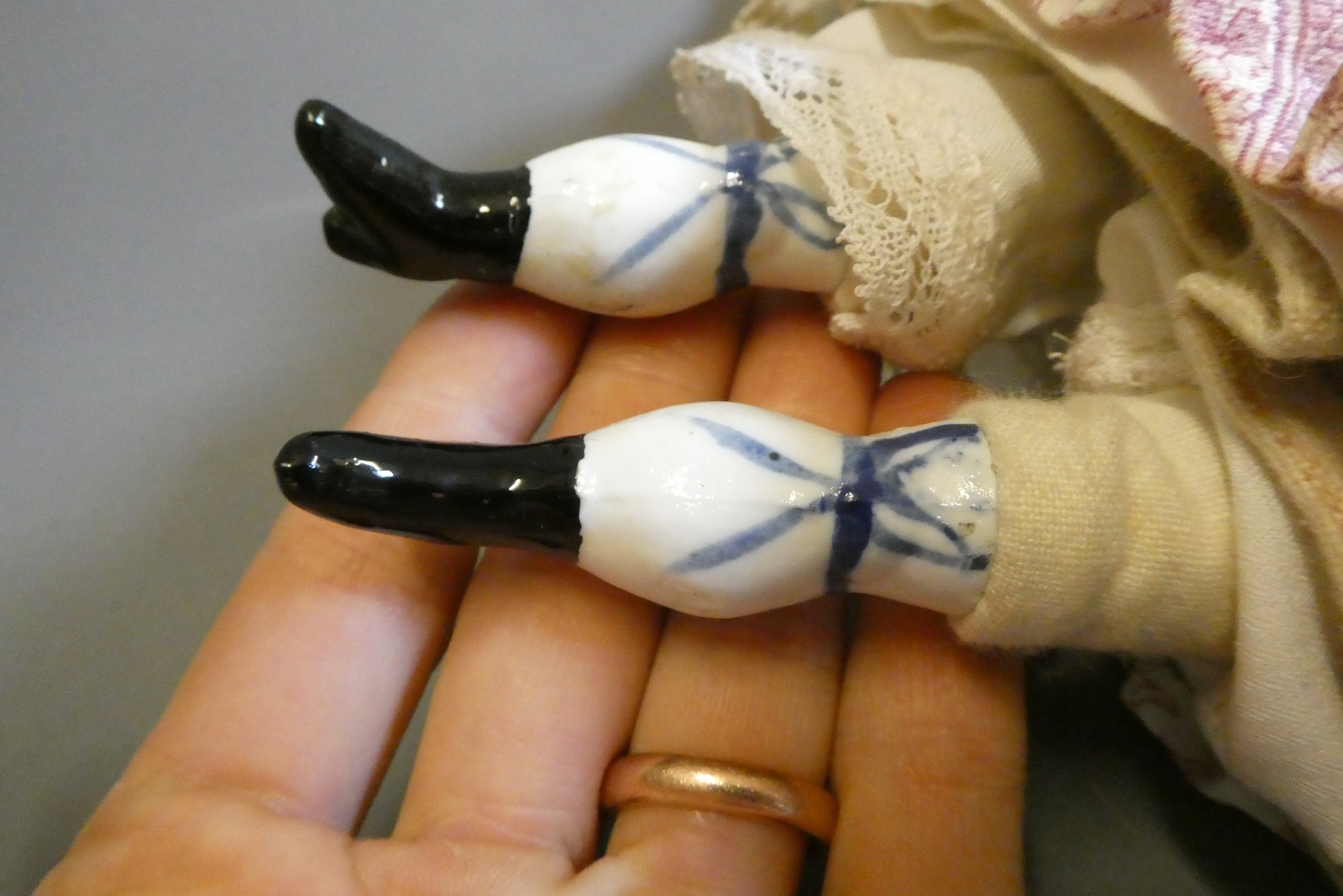 A Victorian china shoulder head doll, with moulded hair, painted features, fabric body, china lower Image
