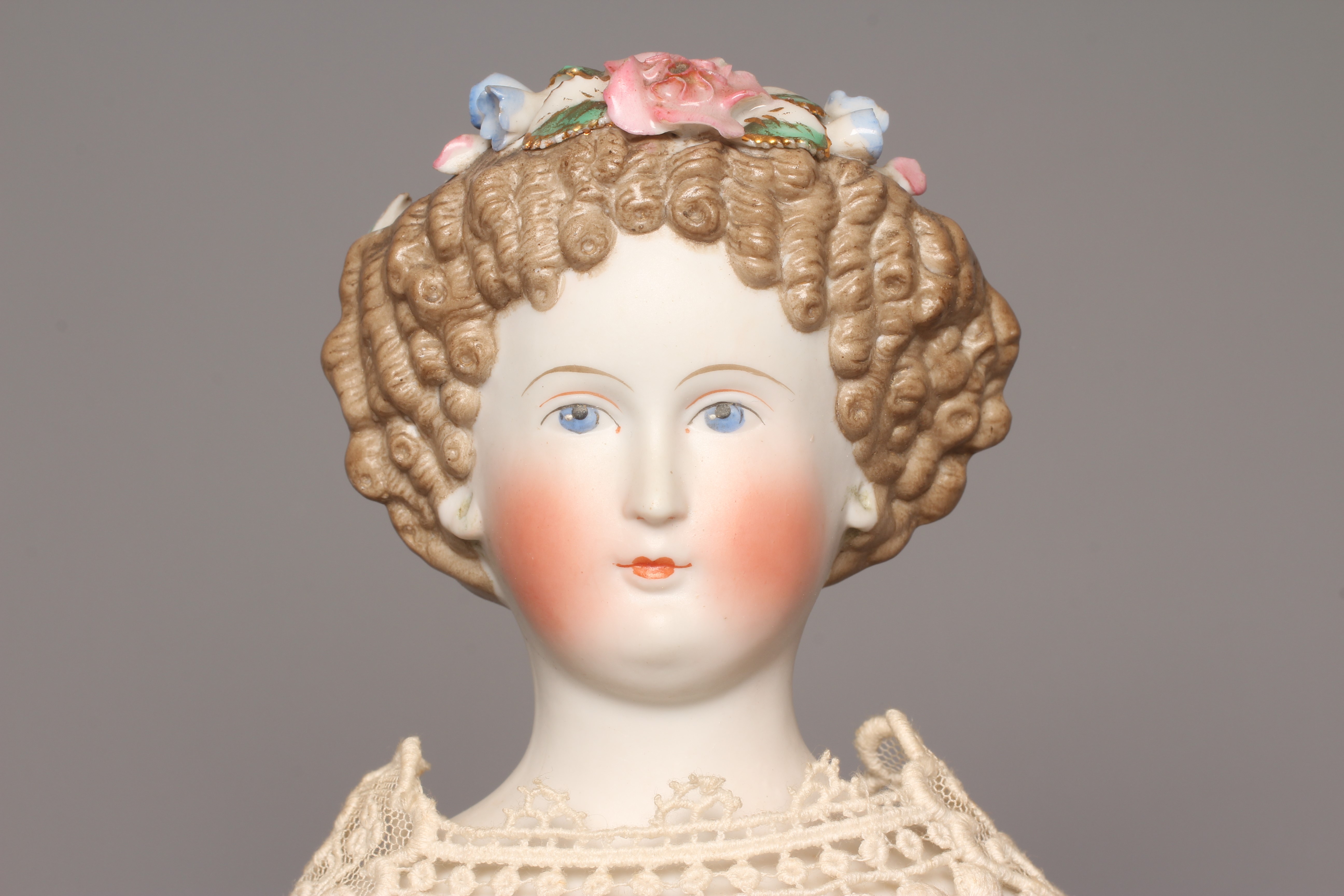 A bisque shoulder head doll, possibly Dornheim, with moulded hair encrusted with flowers, painted Image