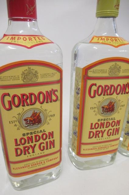 4 bottles of Gordons gin comprising 1 vintage 26.6fl.oz. snap cap top bottle Image