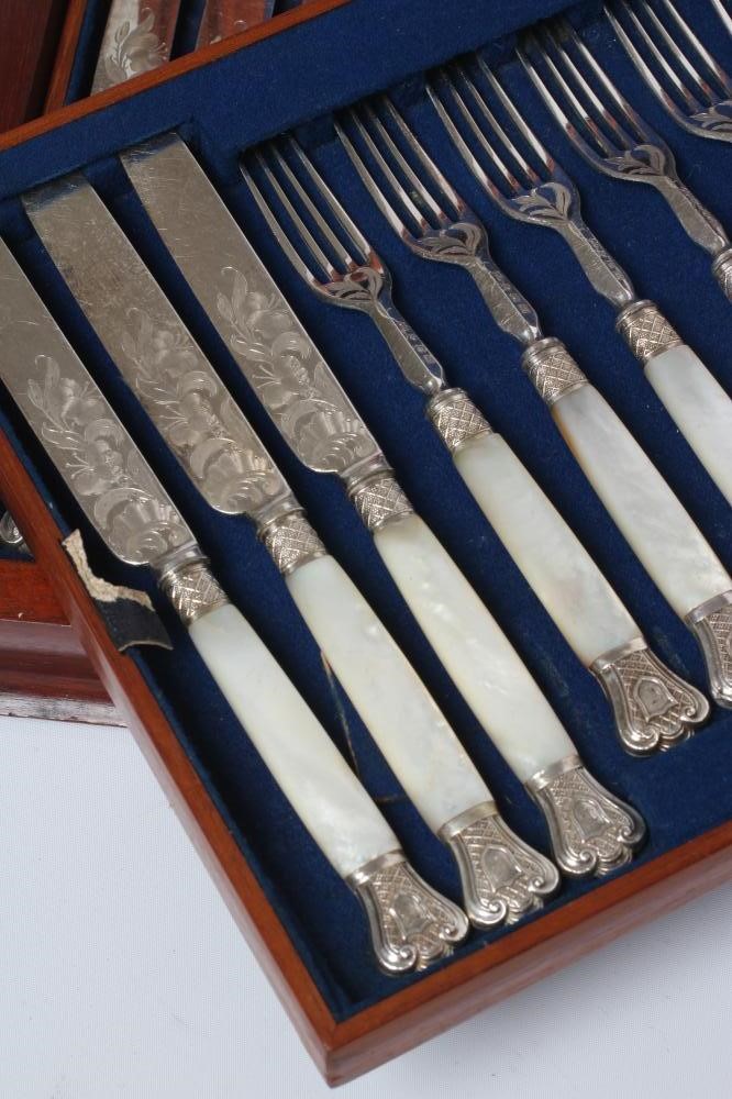 A SET OF TWELVE PAIRS OF VICTORIAN EPNS DESSERT KNIVES AND FORKS with scroll engraved blades and Image