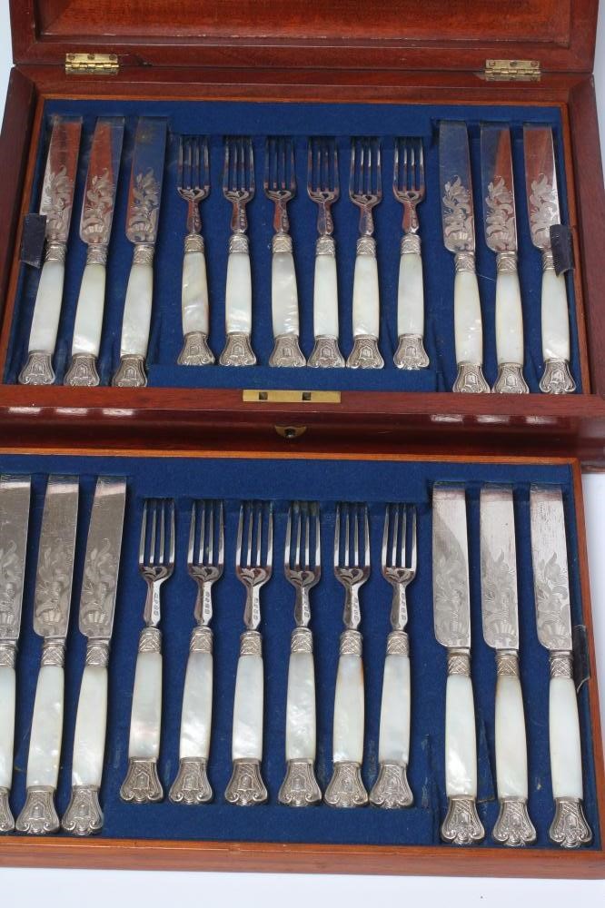A SET OF TWELVE PAIRS OF VICTORIAN EPNS DESSERT KNIVES AND FORKS with scroll engraved blades and Image