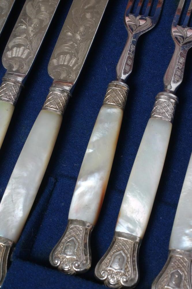 A SET OF TWELVE PAIRS OF VICTORIAN EPNS DESSERT KNIVES AND FORKS with scroll engraved blades and Image