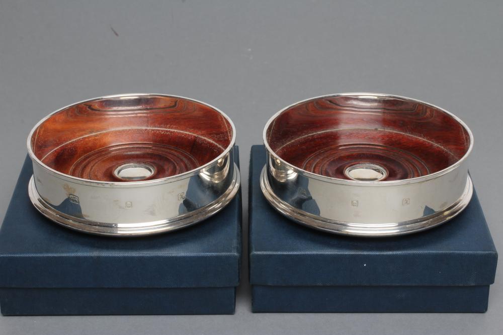 A PAIR OF SILVER BOTTLE COASTERS Image