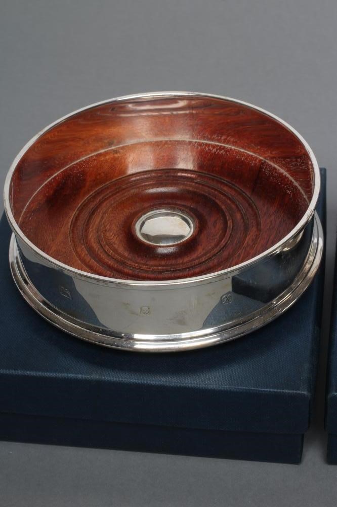 A PAIR OF SILVER BOTTLE COASTERS Image