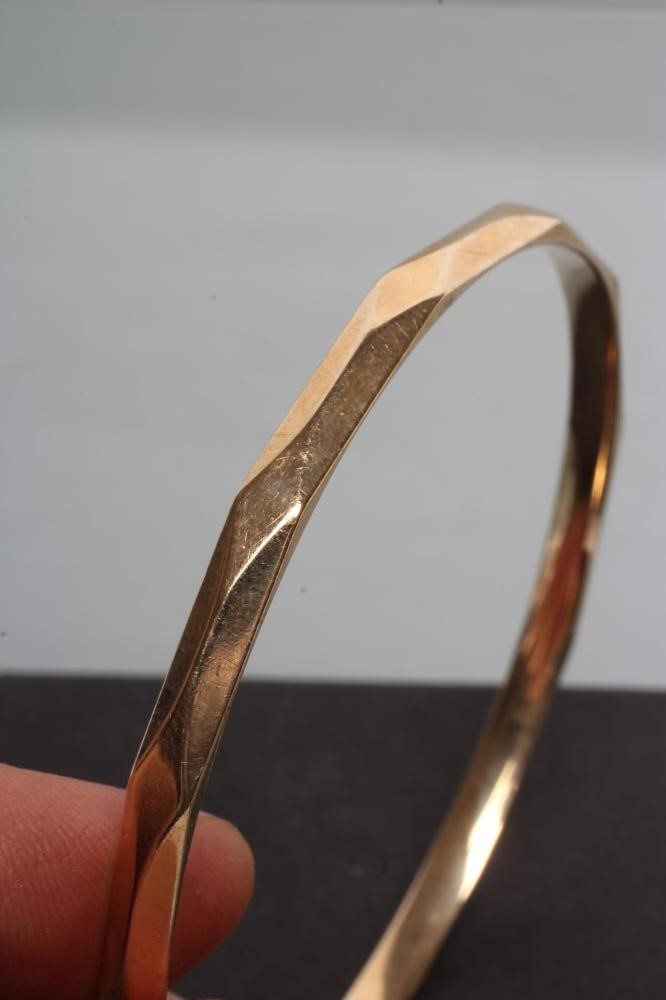A 9CT GOLD BANGLE of faceted circular form Image