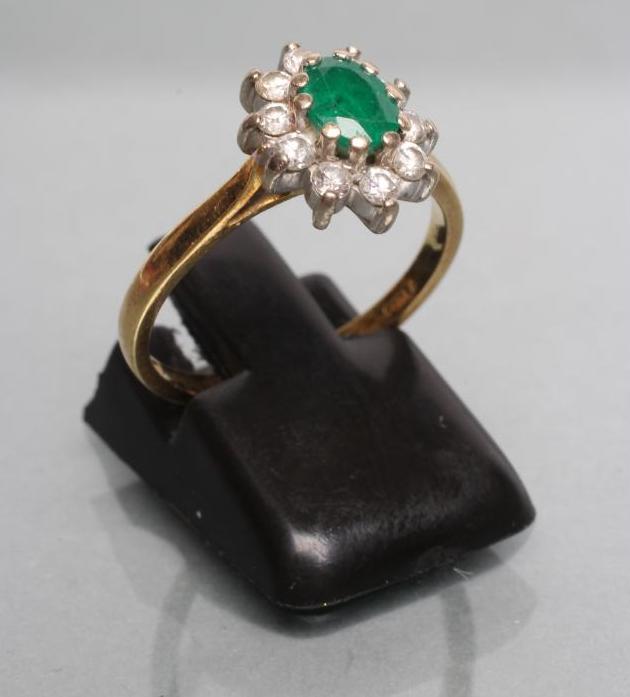 AN EMERALD AND DIAMOND CLUSTER RING Image