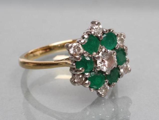 A DIAMOND AND EMERALD CLUSTER RING Image