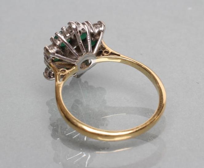 A DIAMOND AND EMERALD CLUSTER RING Image