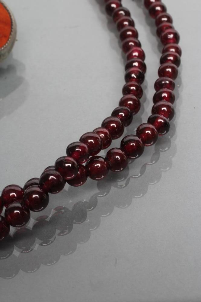 A DOUBLE STRING OF POLISHED GARNET BEADS Image