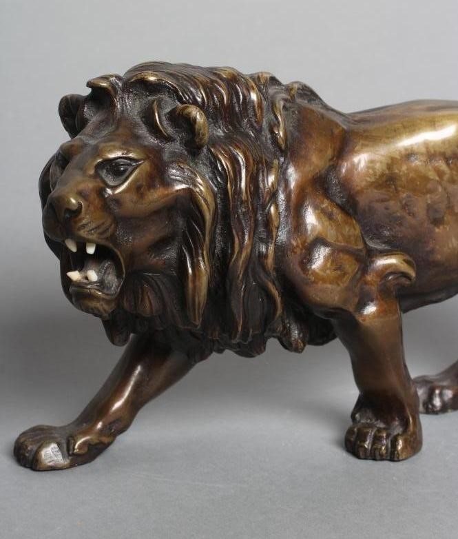 A BRONZE MODEL OF A ROARING LION modelled standing Image