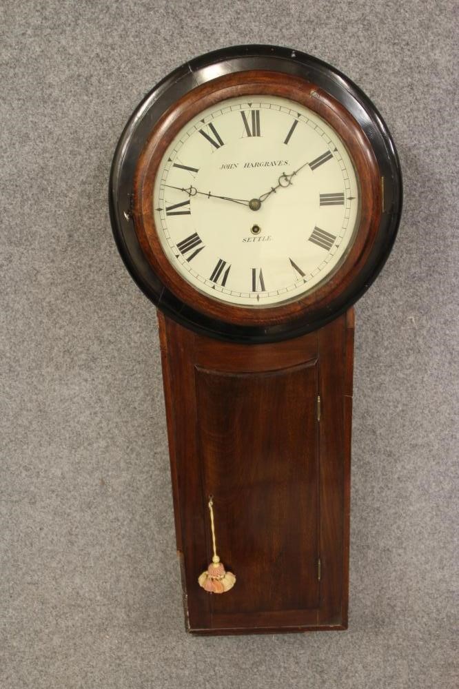 A MAHOGANY AND EBONISED CARVED TAVERN CLOCK by John Hargreaves Image