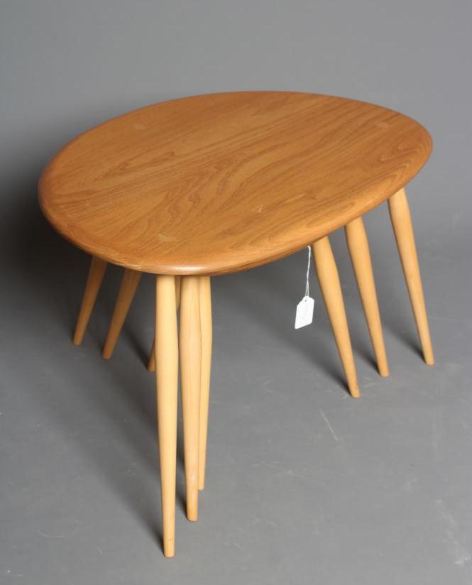 AN ERCOL BEECH AND ELM NEST OF THREE "PEBBLE" TABLES Image