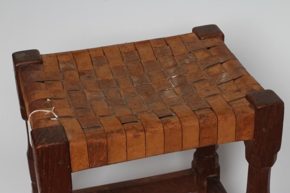 A ROBERT THOMPSON OAK STOOL of oblong form with lattice leather seat Image