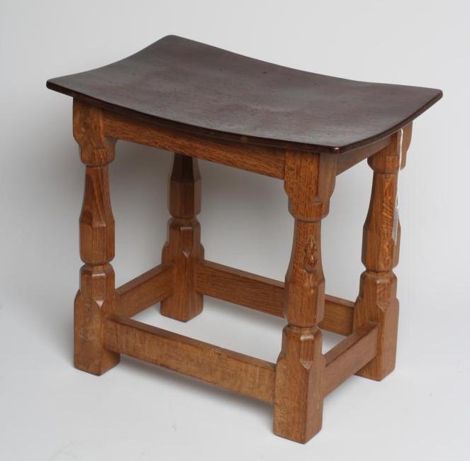 A ROBERT THOMPSON ADZED OAK STOOL of dished oblong form with faceted baluster turned and block legs Image