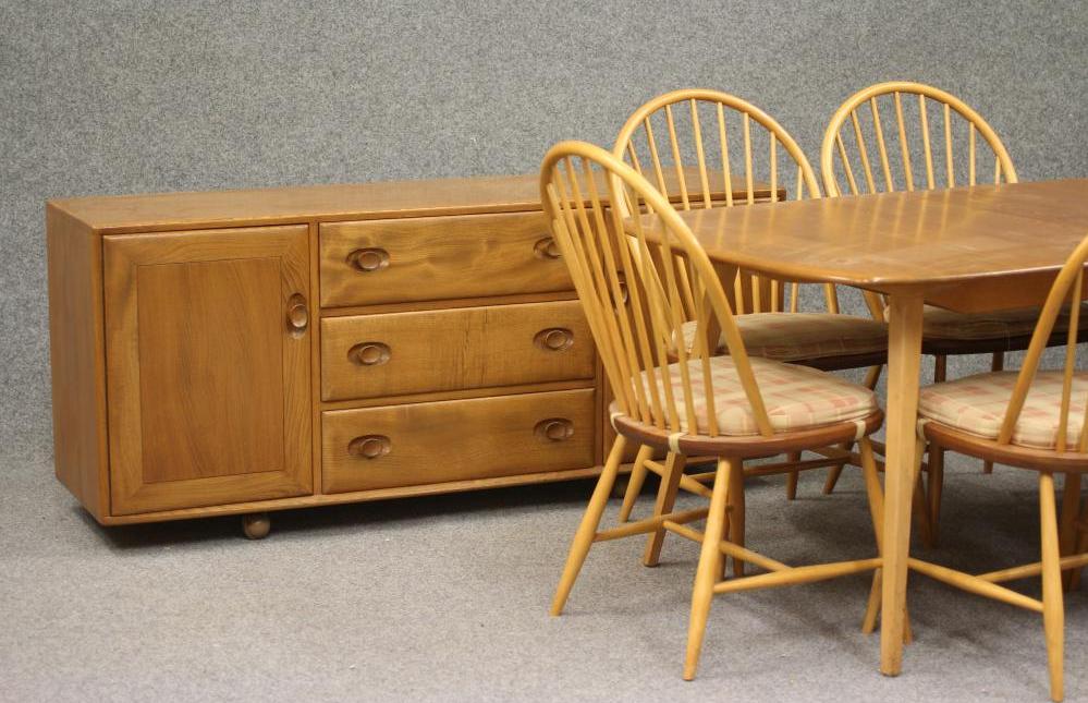 AN ERCOL WINDSOR BEECH AND ELM DINING SUITE comprising an extending table with rounded oblong top Image