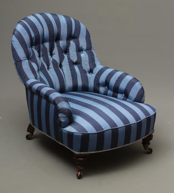 A VICTORIAN WALNUT AND IRON FRAMED ARMCHAIR button upholstered in blue striped watered silk Image