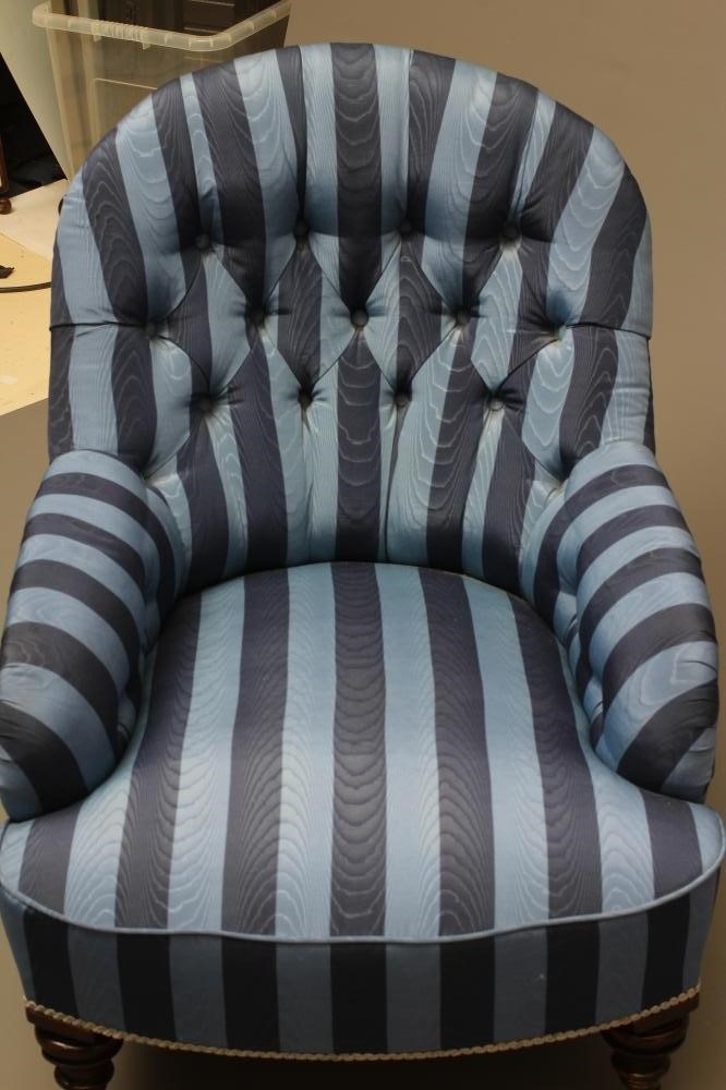 A VICTORIAN WALNUT AND IRON FRAMED ARMCHAIR button upholstered in blue striped watered silk Image