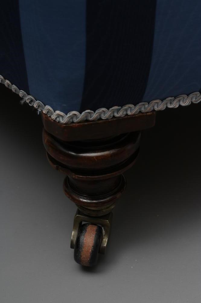 A VICTORIAN WALNUT AND IRON FRAMED ARMCHAIR button upholstered in blue striped watered silk Image