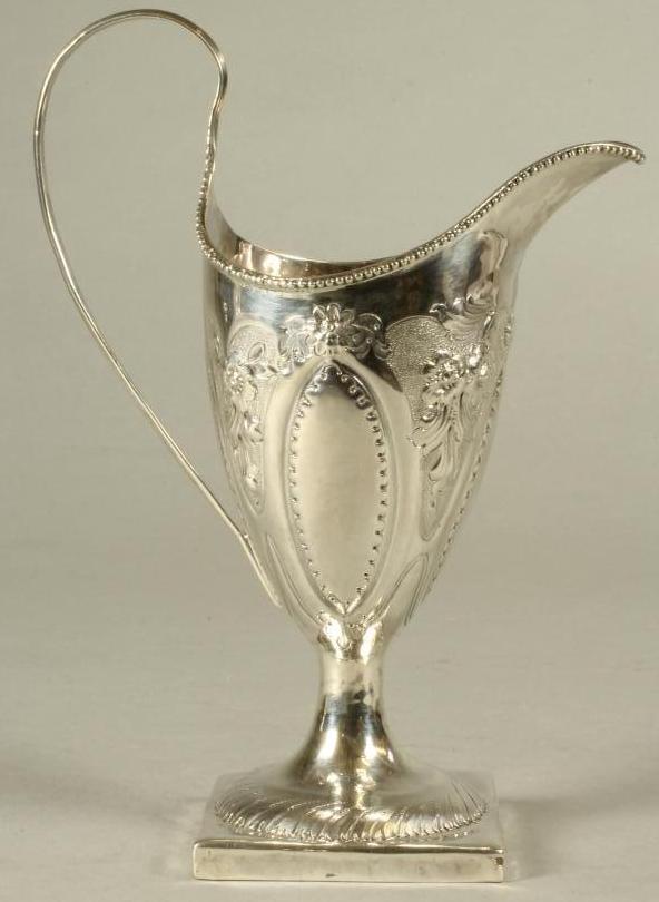 A LATE GEORGE III SILVER PEDESTAL HELMET MILK JUG Image