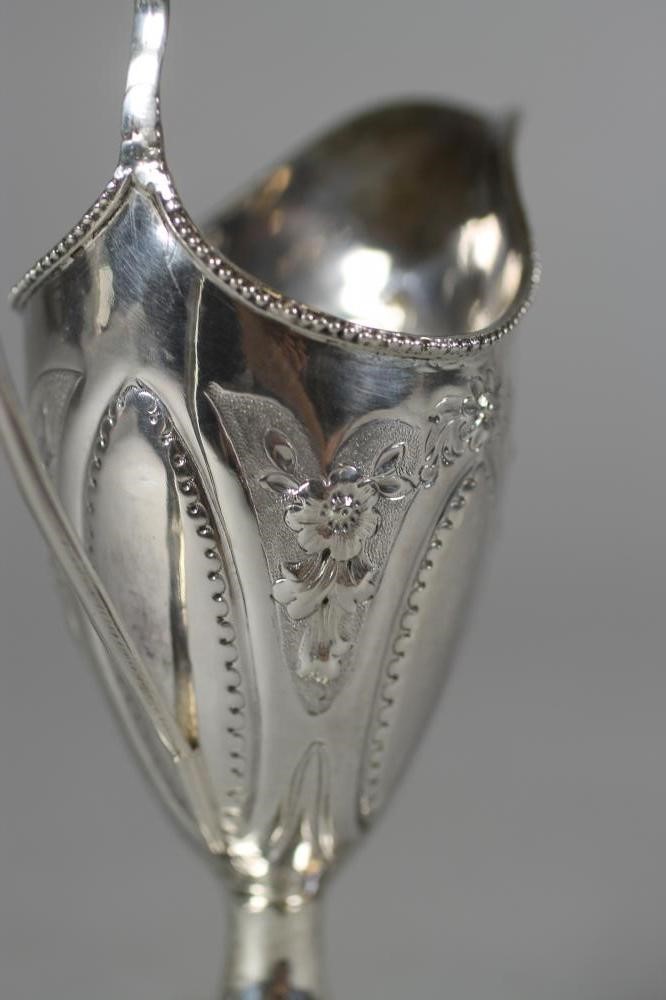 A LATE GEORGE III SILVER PEDESTAL HELMET MILK JUG Image